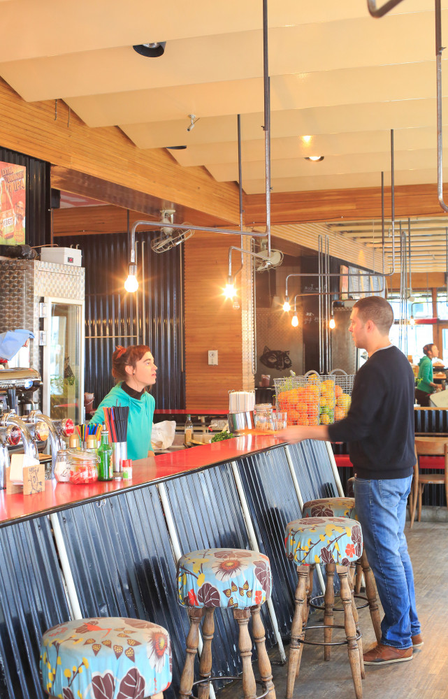 Un piano, un vélo suspendu au-dessus d’une banquette en Skaï et, au bar en tôle et lattes...