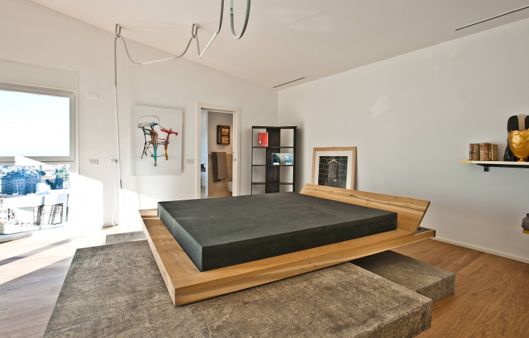 Dans la chambre, Rossana Orlandi a installé une pièce unique, le lit en bois et pierre de Matteo Casalegno. Installation lumineuse d’Os & OOS.