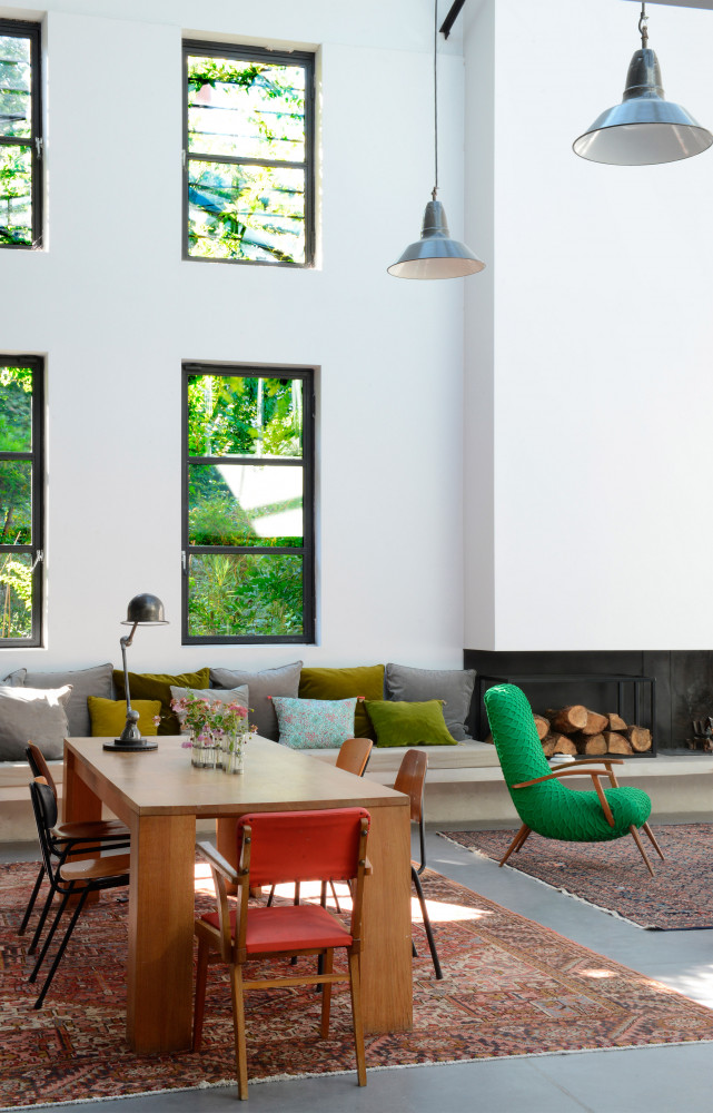 A Montreuil, un loft hors normes Cécile a dessiné la cheminée et son prolongement en assise sur laquelle sont disposés des coussins (Caravane,...