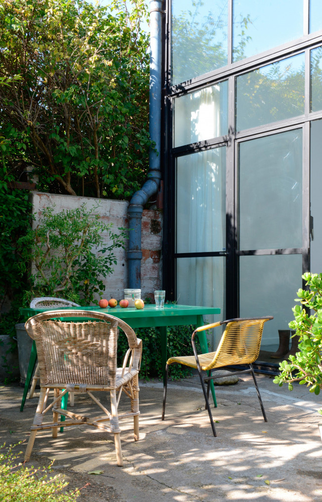 Table (Tolix) entourée de chaises chinées.