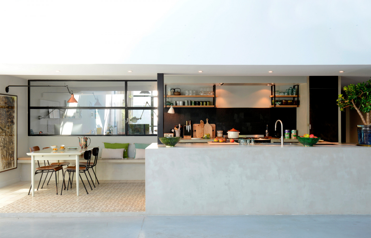 Table et chaises chinées. Crédence noire (Carrelages du Sud). Étagères dessinées par Cécile. En arrière-plan, les bureaux...