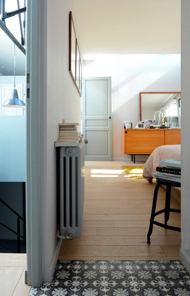 Dans la chambre, le sol est réchauffé d’un parquet en chêne blanchi. Commode et miroir chinés. Lampe...