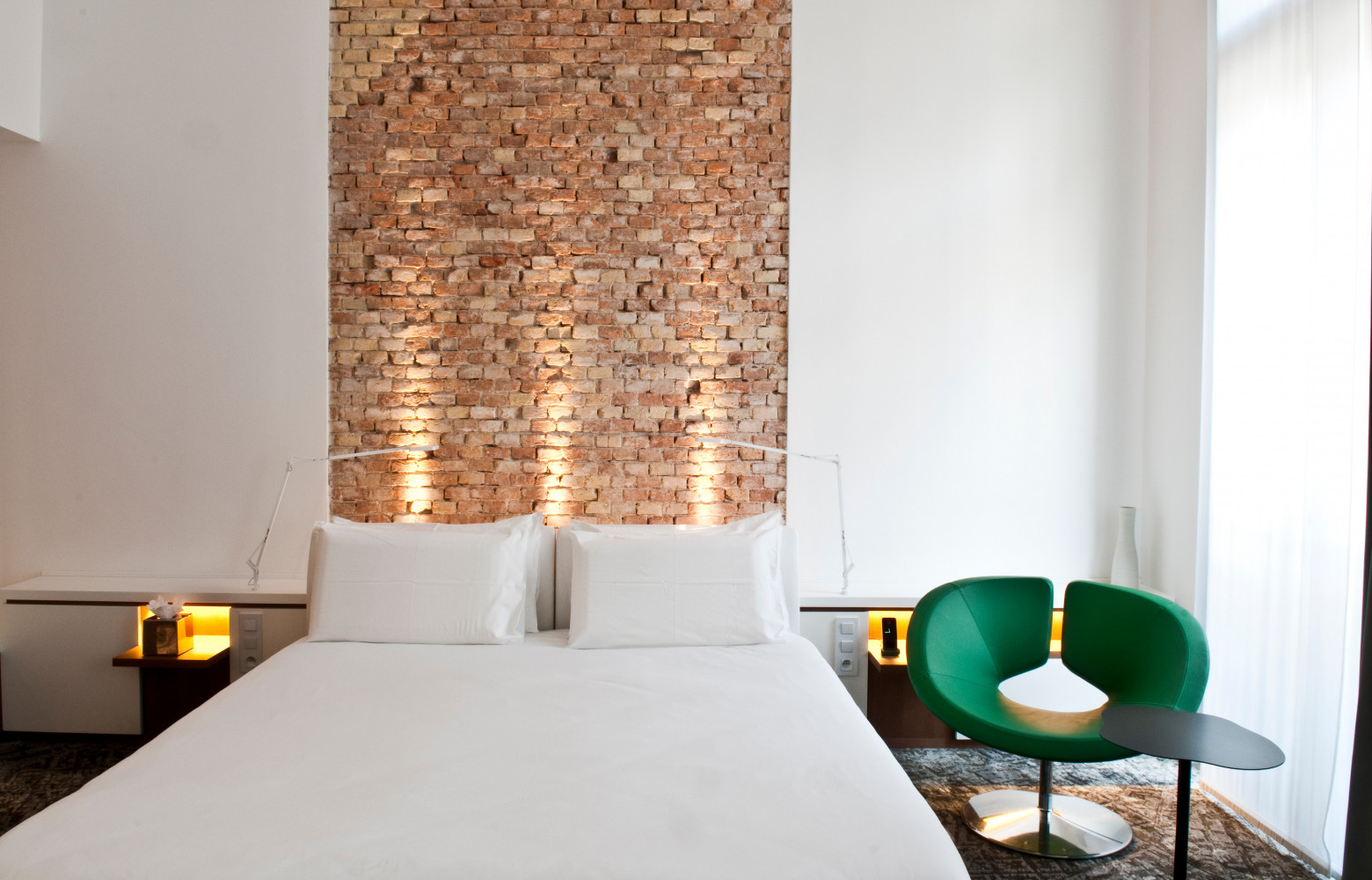 Dans cette chambre, la tête de lit a été réalisée en brique.