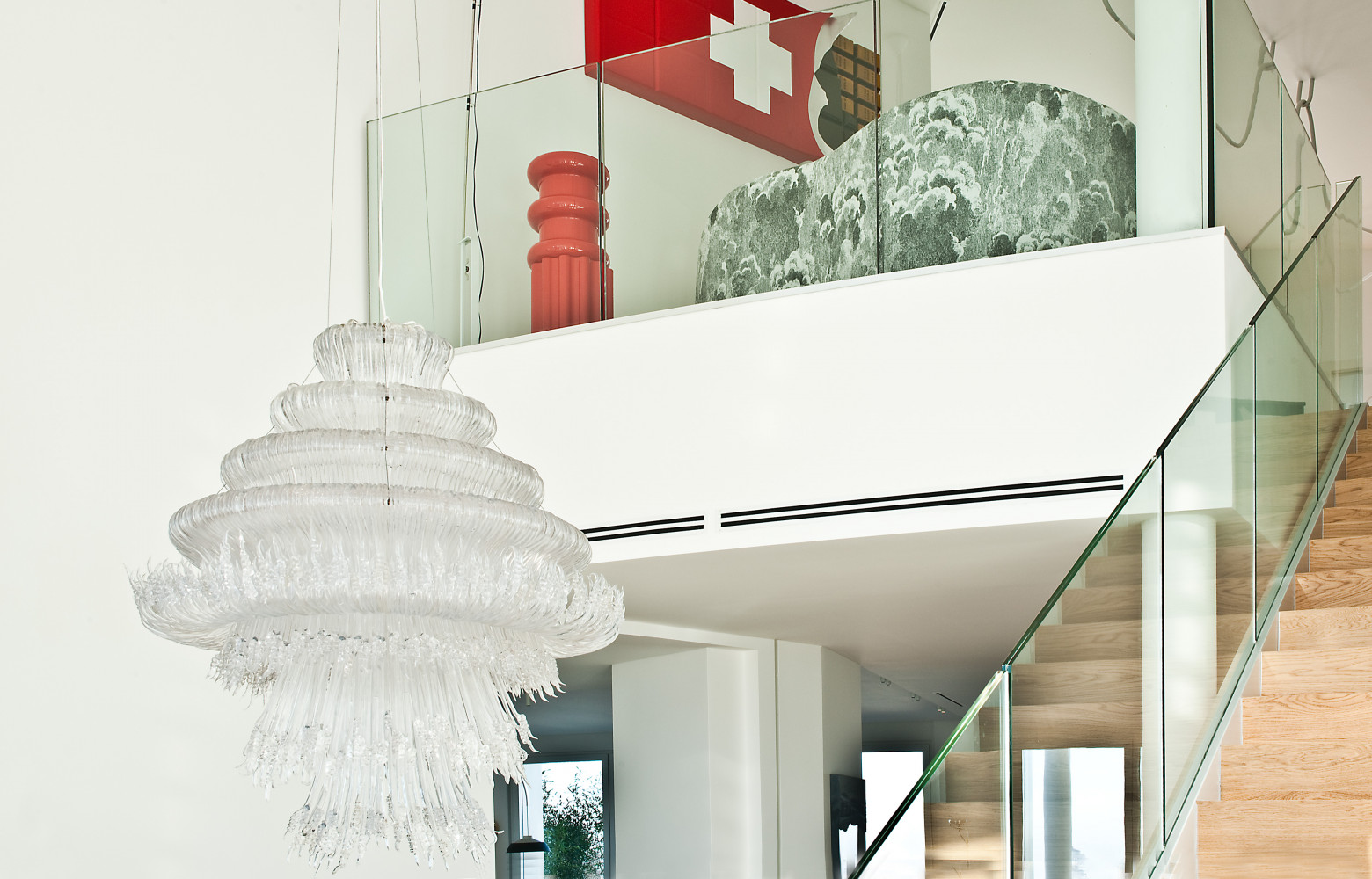 Lustre "Sneeze", de Jacopo Foggini. Sur la mezzanine, deux vases rouges "Calice" de la collection "Kartell Goes...