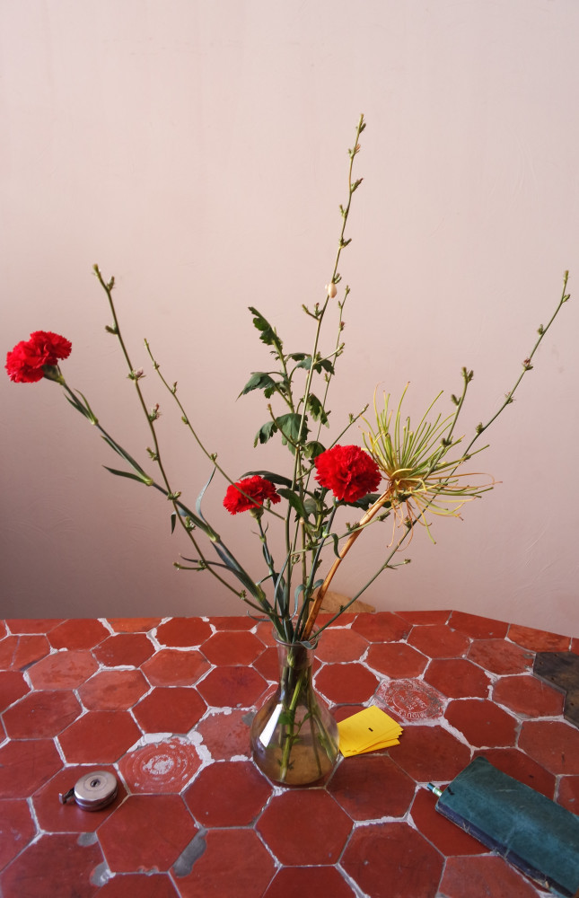 Less is more… Ici, quelques tiges, trois œillets posés sur une table en tomettes de Salerne… Un...
