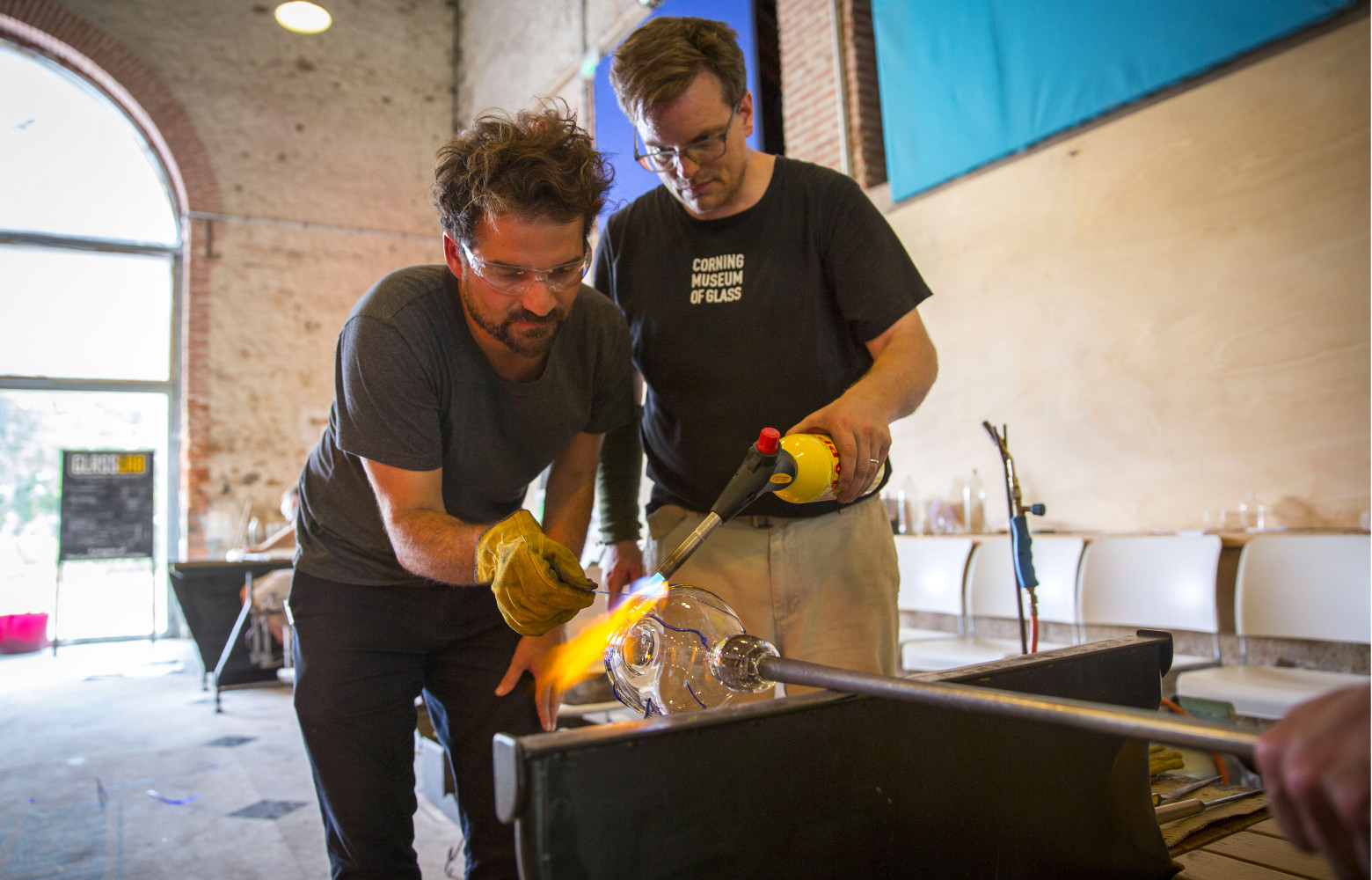 Jaime Hayon aidé par un technicien de GlassLab pour terminer sa pièce.