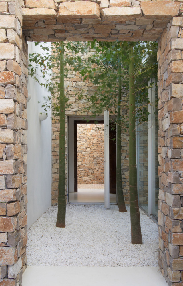 Une succession d’ouvertures relie l’entrée à la terrasse avec vue sur mer. Au centre, un patio à...