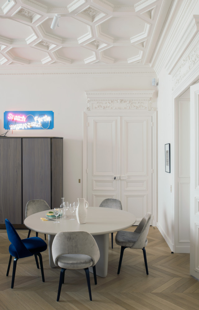 Au plafond, les modénatures haussmanniens ont été soigneusement préservés. Chaises « Executive » d'Eero Saarinen (Knoll), table...