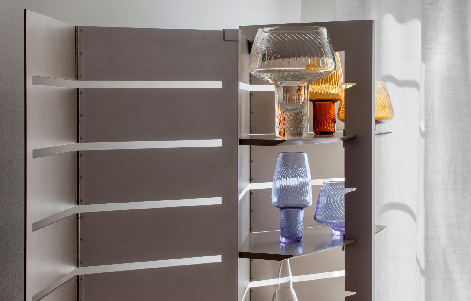 Le paravent à rayonnages en acier Centrale (Idée) accueille une collection de coupes et de vases en...