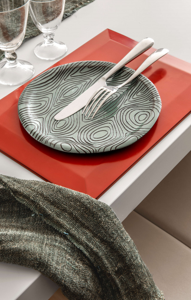 Côté repas, sur le set de table en laque rouge à pans biseautés japonais, assiette à ciselures...