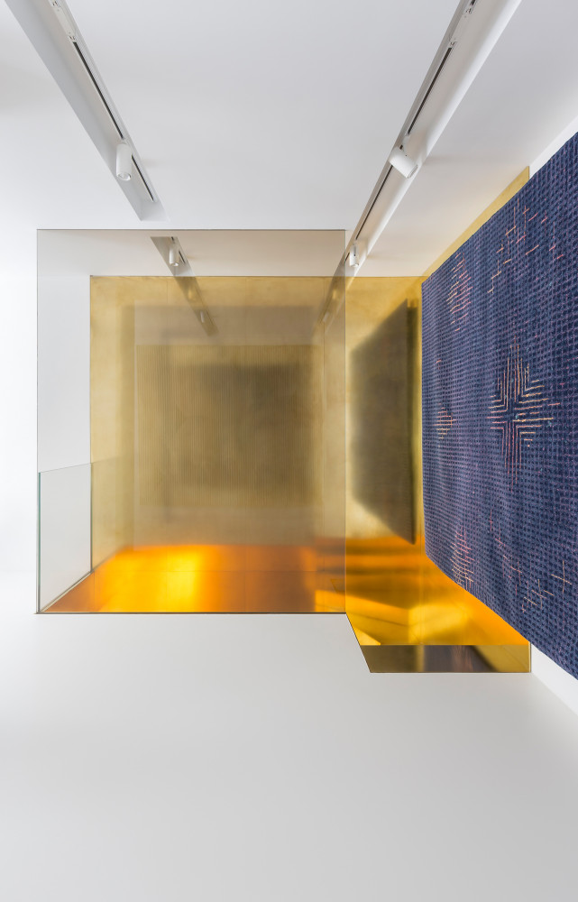 Des grandes plaques de verre et de laiton dorés apporte un jeu de profondeur qui sublime les...