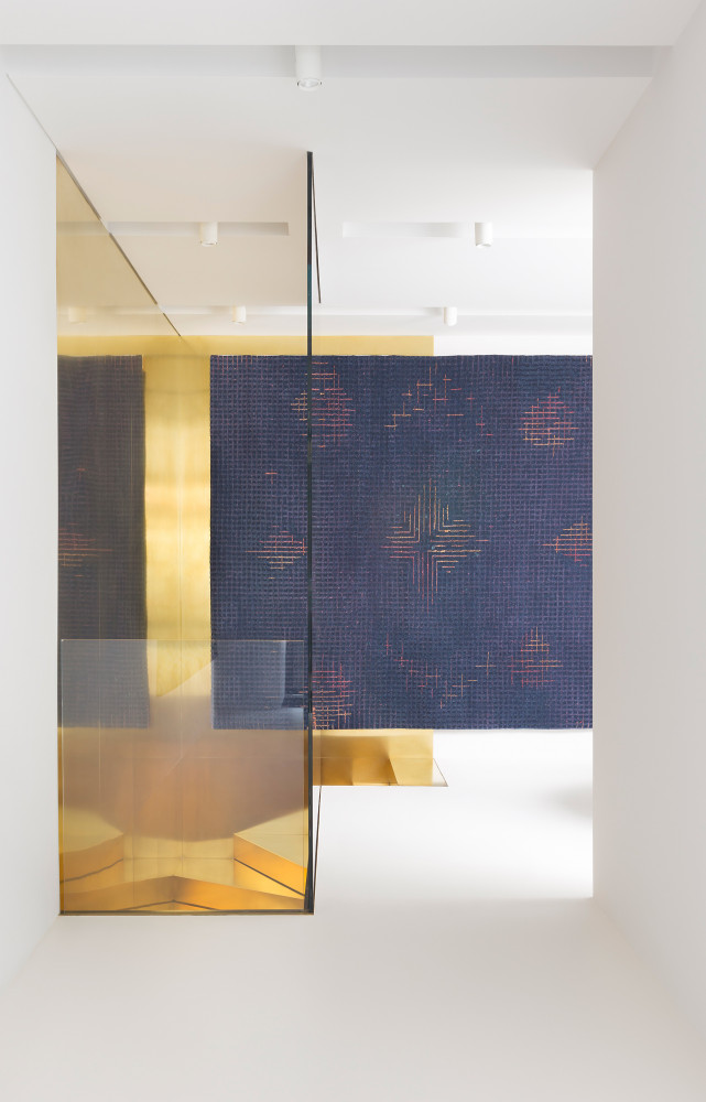 Des grandes plaques de verre et de laiton dorés apporte un jeu de profondeur qui sublime les...