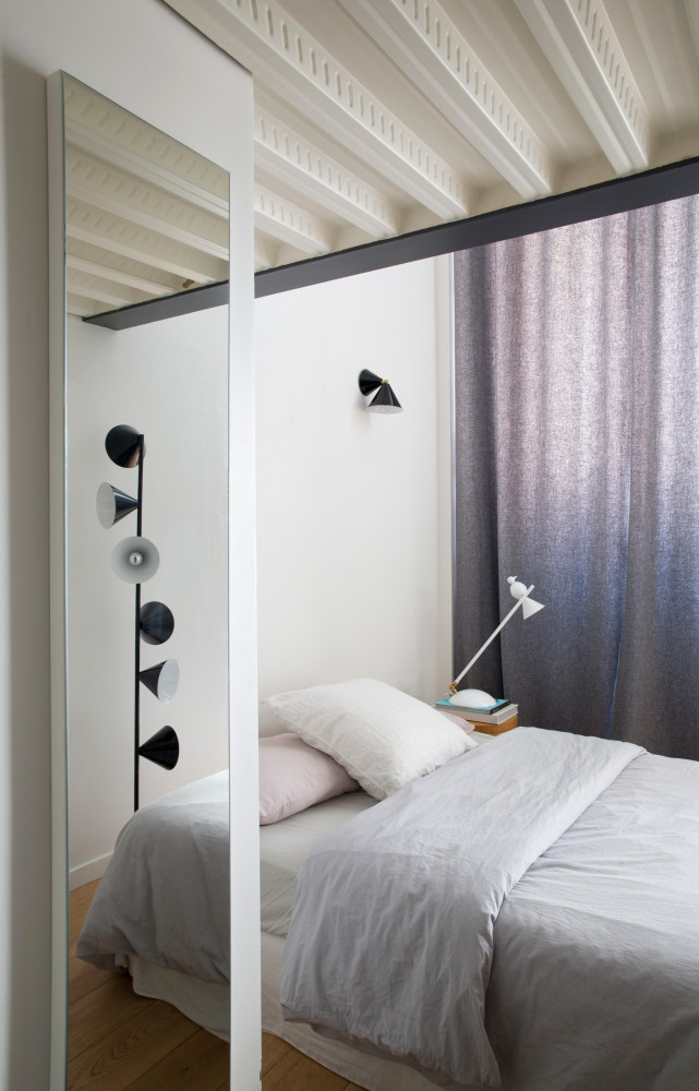 Dans la chambre, ambiance feutrée où la couleur n’a pas sa place. Luminaires Atelier Areti.