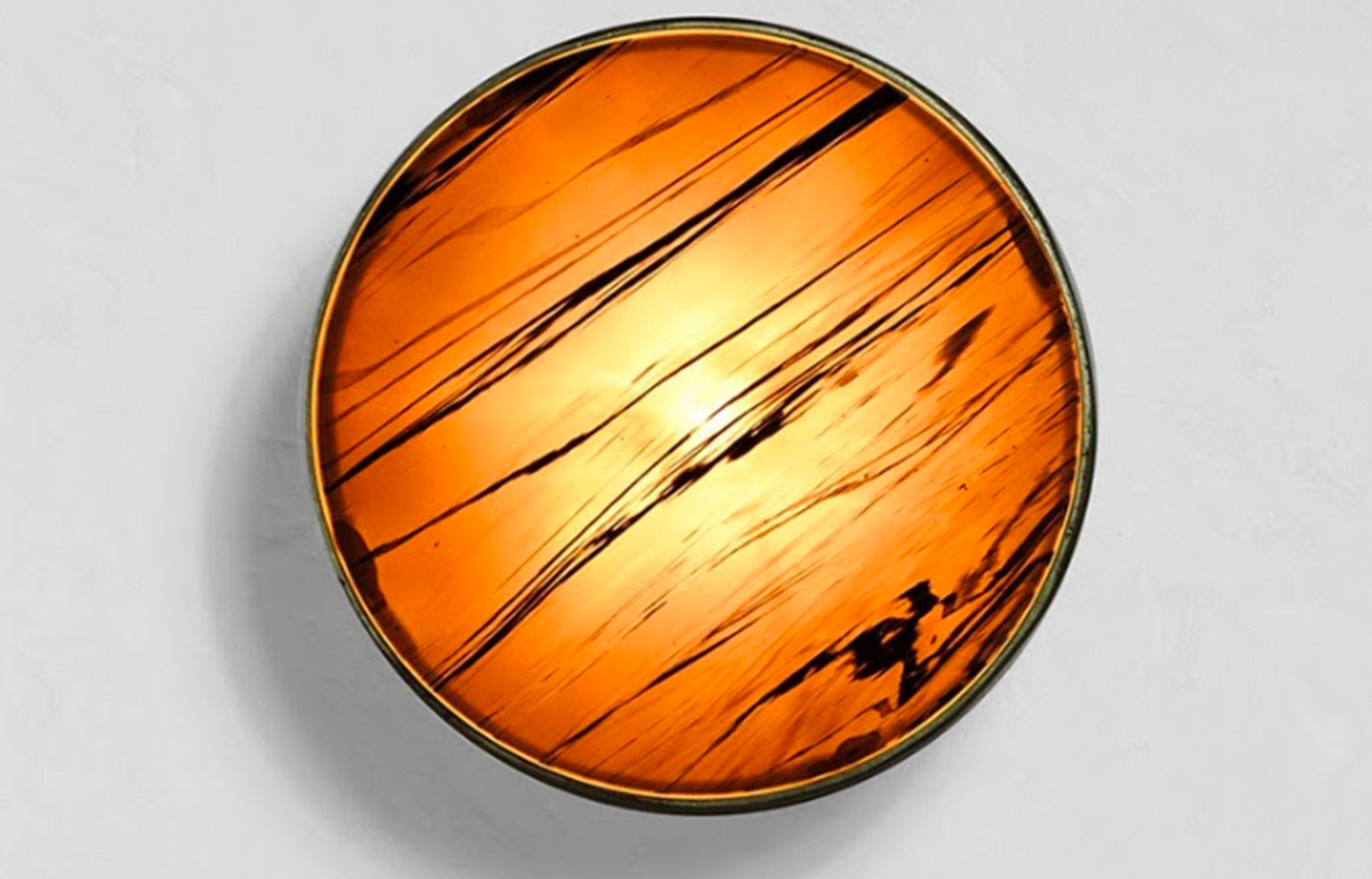 Applique en bronze fondu au sable patiné à chaud, disque d’obsidienne serti. Des pièces numérotées et signées.