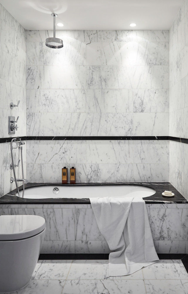 La salle de bains est dallée de marbre Calacatta et Nero Marquina. Robinetterie Lefroy Brooks.