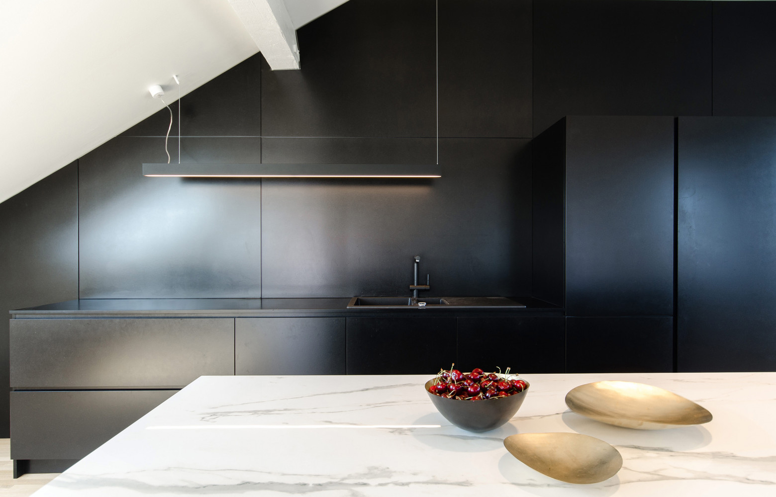 En associant uniquement trois matériaux, le bois brut, le MDF noir teinté dans la masse et la...