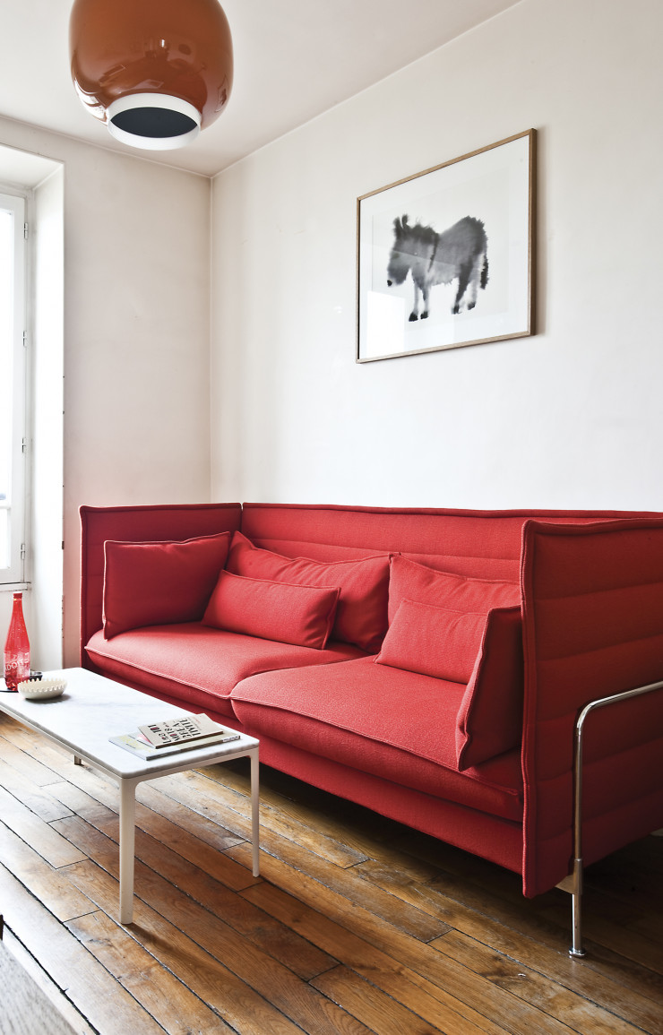 À la maison, le sofa Alcove des Bouroullec (Vitra) sous la suspension Chouchin qu’elle a conçue pour Foscarini.