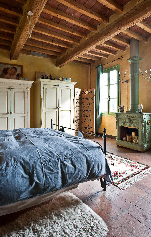Dans la vaste chambre parentale, mobilier et accessoires vintage prédominent, à l’instar du poêle à bois.