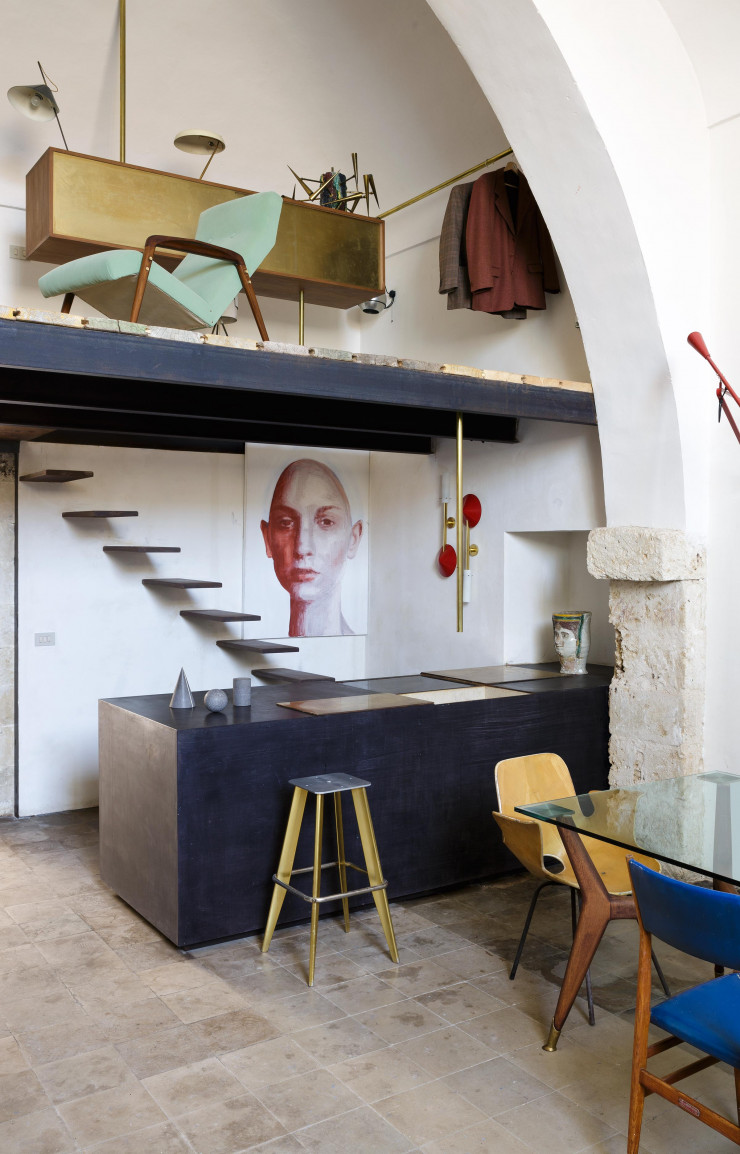 La cuisine, où se côtoient l’acier et le laiton, a été conçue par Sergio Fiorentino. Sur le plan de travail, un traditionnel vase Testa di Moro, en majolique de Caltagirone, date de 1860. Le peintre est aussi le designer des meubles de la chambre à coucher, à l’étage.
