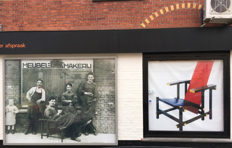 Une photo d’époque et une reproduction de la chaise Rouge-Bleu s’affichent sur le bâtiment qui abrita le premier atelier de Rietveld.