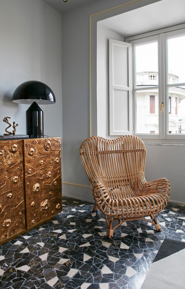 Au pied de l’iconique lampe « Atollo » de Vico Magistretti (Oluce), une réédition du fauteuil en...