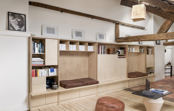 Dans le léger renfoncement de la pièce a été installée une bibliothèque-banquette en contreplaqué de bouleau, dessinée avec à l’esprit le mobilier minimaliste de Donald Judd.