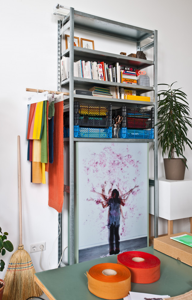 Des étagères industrielles permettent de ranger livres et documents de travail.