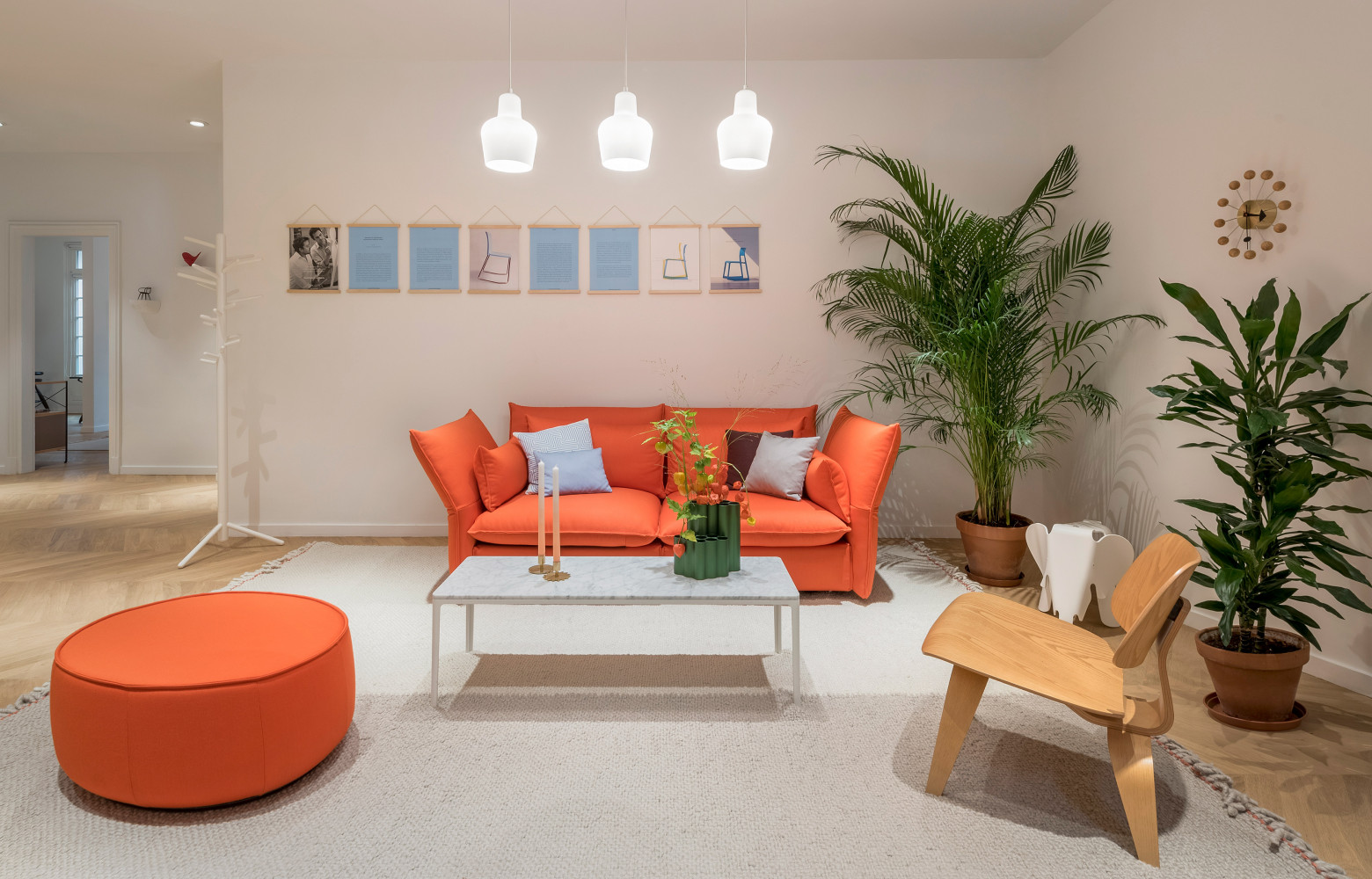 Dans le salon d'accueil, canapé orange Mariposa de Barber & Osgerby et suspensions A440 d'Alvar Aalto (Artek).
