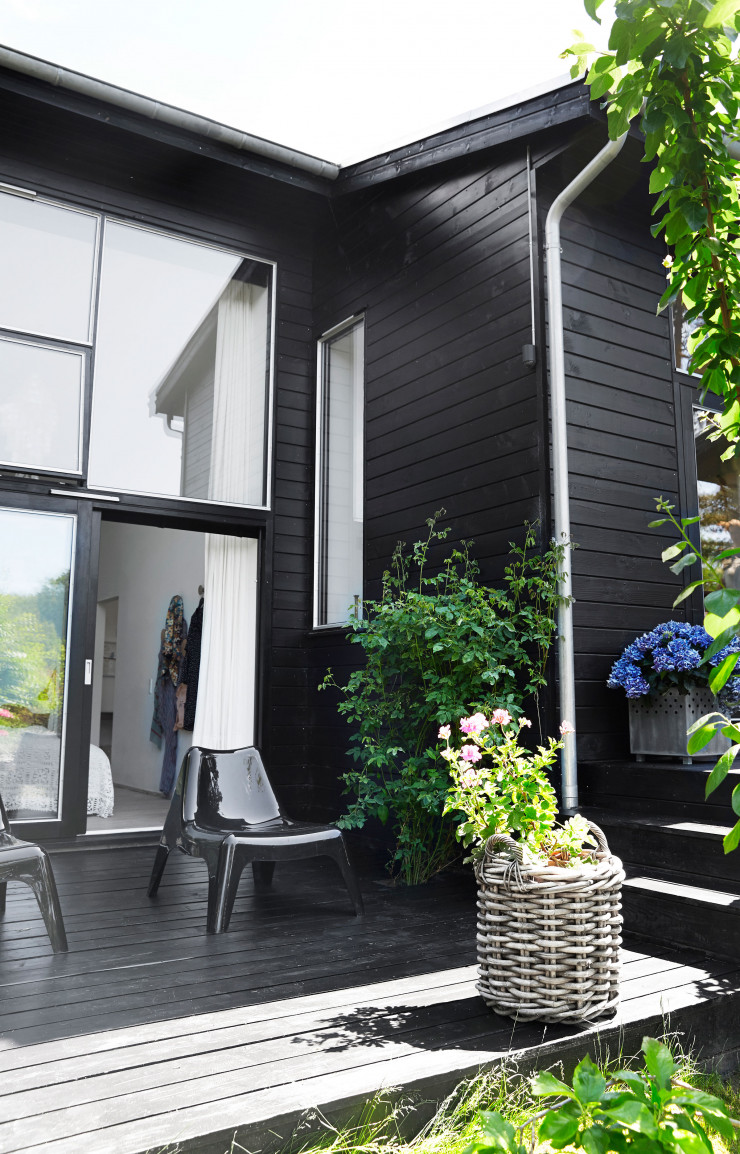Devant la chambre, la terrasse et ses fauteuils noirs Ikea PS Vågö.