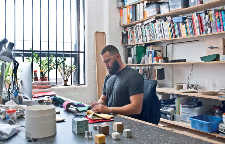 Philippe Malouin devant des échantillons de tissus et de matériaux dans son studio de l’East London.