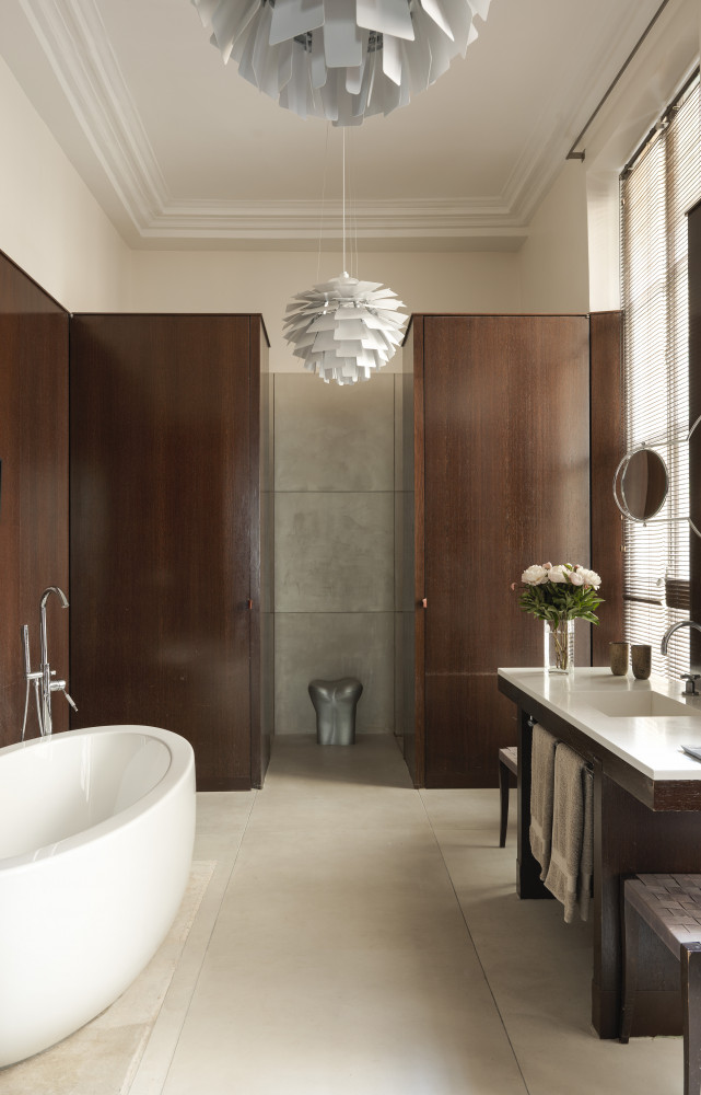  Dans la salle de bains, un sol en béton fait ressortir un meuble avec vasque et des...