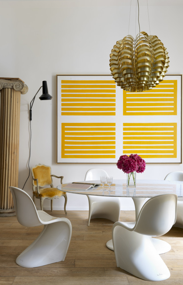 Un plafonnier en laiton des années 70 domine une table à manger de la collection « Pedestal » imaginée par...