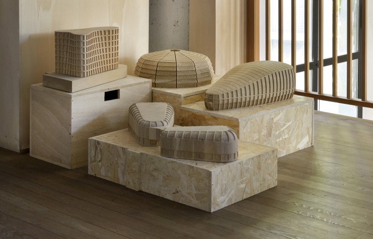 Sur un palier, un groupe de modèles d’architectures réalisés en bois.