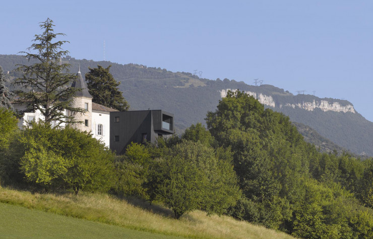 La résidence d’artiste oppose les angles de sa tour d’habitation au galbe de celle qui occupe le domaine depuis le XVIe siècle.