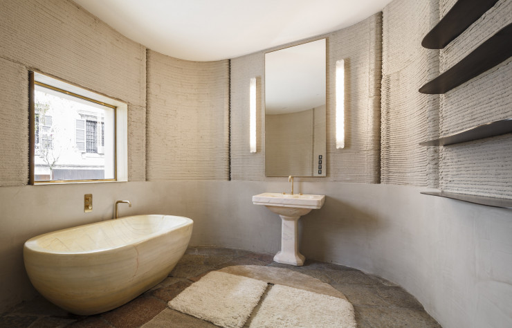 Dans la salle de bain, le marbre et les encadrements de fenêtres en laiton s’accordent à l’aspect intemporel du béton.