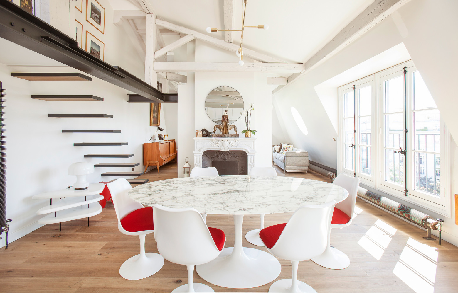 La salle à manger est structurée autour d'une table et de chaises Tulip (Knoll).