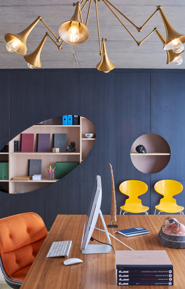 Dans le bureau, bibliothèque de Selig & Renault fabriquée par Acom Agencement. Sur les étagères, cahiers Louise Roe. Au...