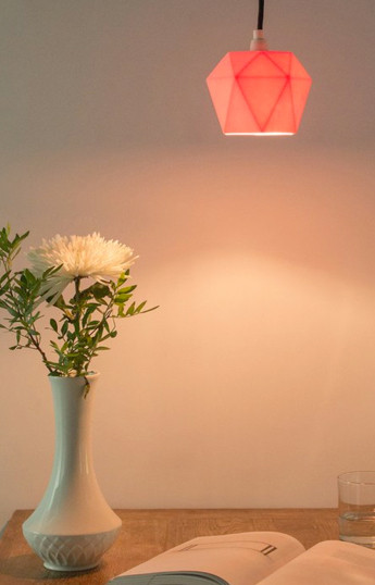 La porcelaine orangée de cette suspension laisse deviner la structure de la lampe lorsqu’elle est allumée. Suspension...