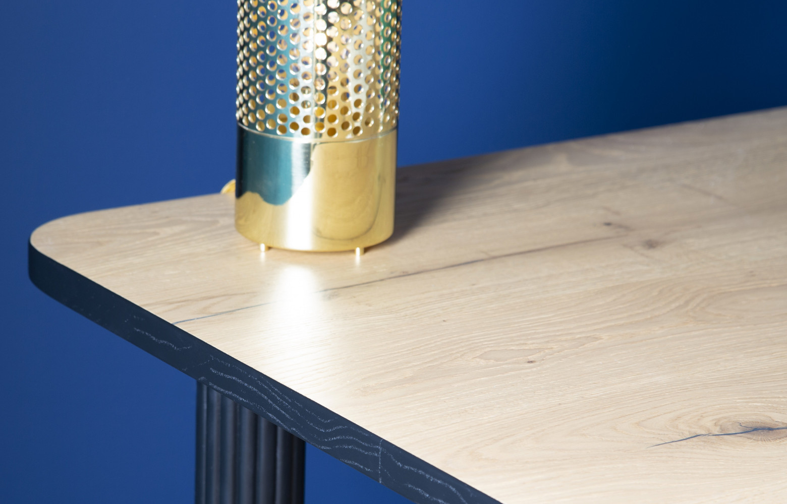 Lampe Sabine en laiton posée sur une table Double Jeu.