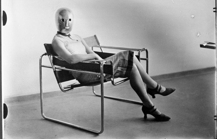 Woman Wearing a Theatrical Mask by Oskar Schlemmer and Seated on Marcel Breuer’s Tubular-Steel Chair (1926).