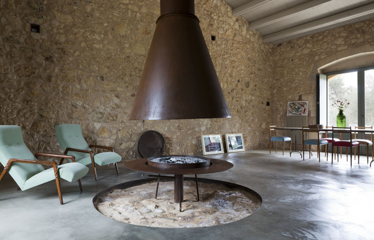 Dans La Casa Farfaglia, l’ancien moulin à huile est devenu l’espace de vie, avec un sol en béton faisant réapparaître l’empreinte circulaire de la meule afin d’accueillir le socle du brasero de la grande cheminée.