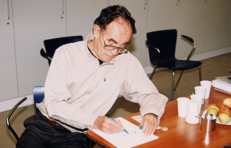 Portrait de Vico Magistretti en plein travail chez Fritz Hansen, assis sur sa chaise Duo réalisée pour l’éditeur danois.