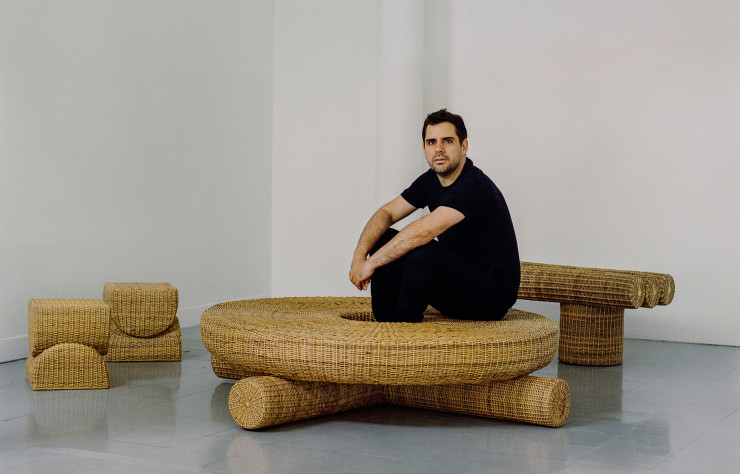 Francisco Jaramillo, créateur de Fango Studio, assis sur la table en basse en yaré qu’il a conçu pour sa première collection.