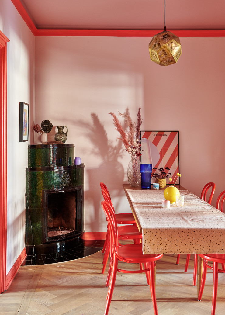 La suspension Etch, design Tom Dixon, surplombe la table de la salle à manger chinée, couverte d’une nappe Granit. Chaises de bistrot Thonet peintes en rouge. Vase jaune du studio Arhoj.