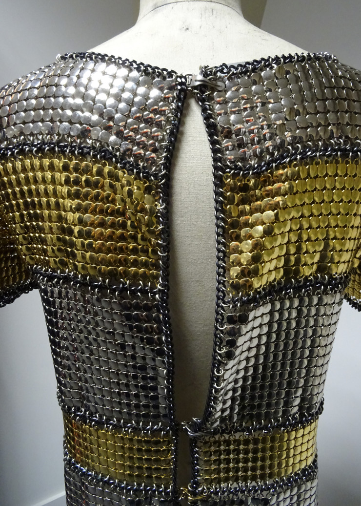 Mini-robe de la collection « Haute couture printemps-été 1967 ». Cotte de mailles dite « squam » en acier chromé et doré, chaînes d’acier noires et anneaux métalliques argentés.