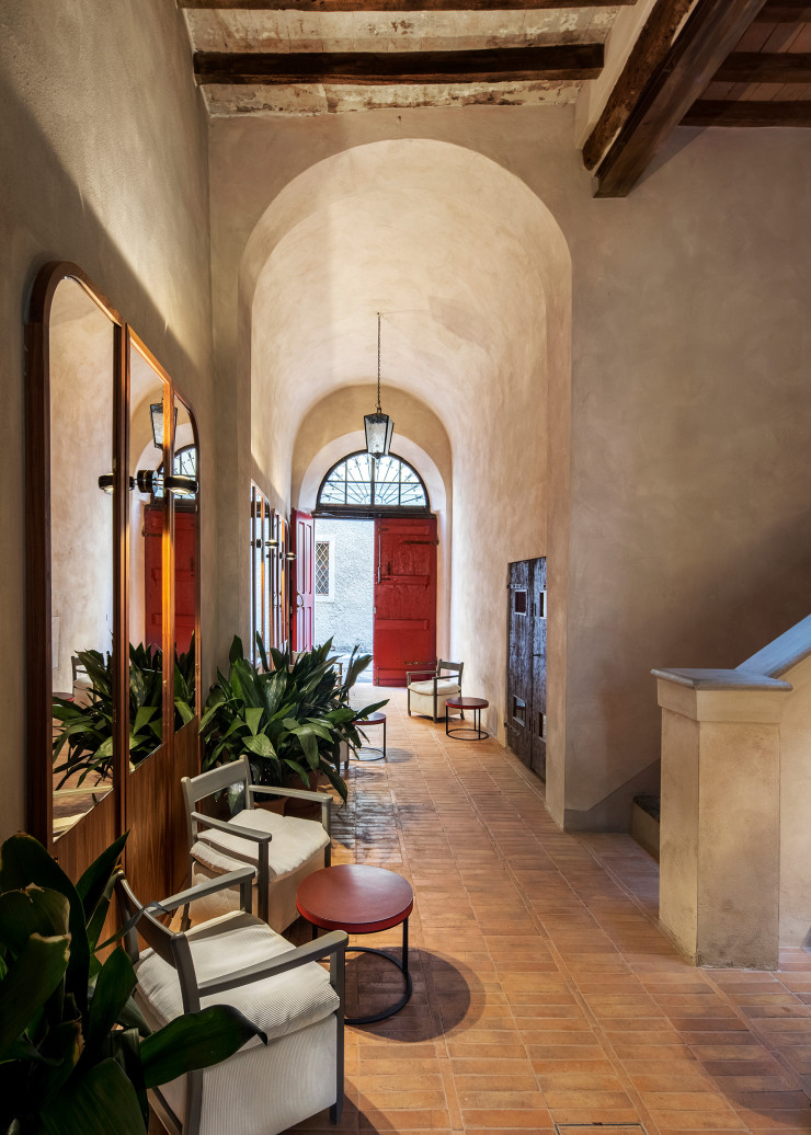 L’entrée avec sa belle hauteur sous plafond a fait l’objet d’une restauration conservatrice, comme l’ensemble de l’auberge. Les murs ont été enduits à la chaux et les sols, recouverts de carreaux en terre cuite. Fauteuils Caccia signés Eligo Studio.