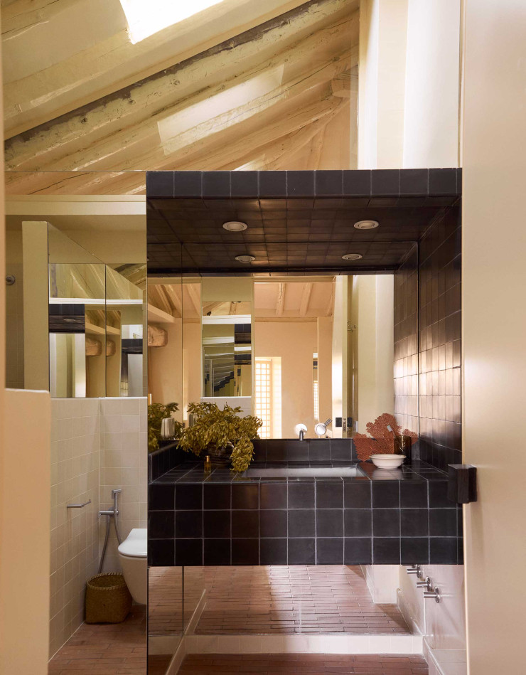 La salle de bain carrelée de noir rappelle le motif damier présent dans le salon.