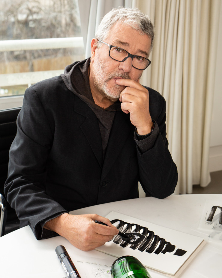 Philippe Starck dessinant la bouteille Perrier + Starck.
