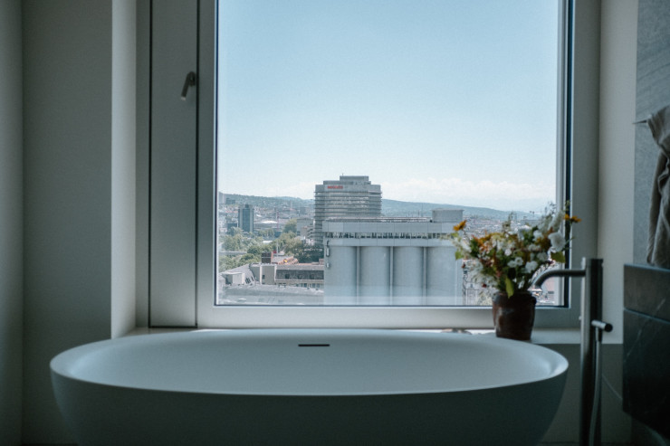 Ambiance hôtel pour la salle de bain et sa baignoire face à la baise vitrée. ©Julien Hay