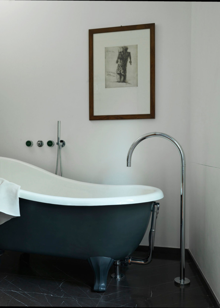 La salle de bains principale dispose d’une baignoire autoportante (Devon&Devon) assortie au sol en marbre gris et aux murs blancs. Lithographie de l’artiste Giuliano Collina.
